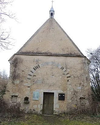 Chapelle Saint-Hilaire des Noyers, "facade" occidentale avec 3 niches et une porte rectangulaire ordinaire entourée de 2 pannonceaux d'affichage, une arcade légèrement surbaissée au dessus, puis le to